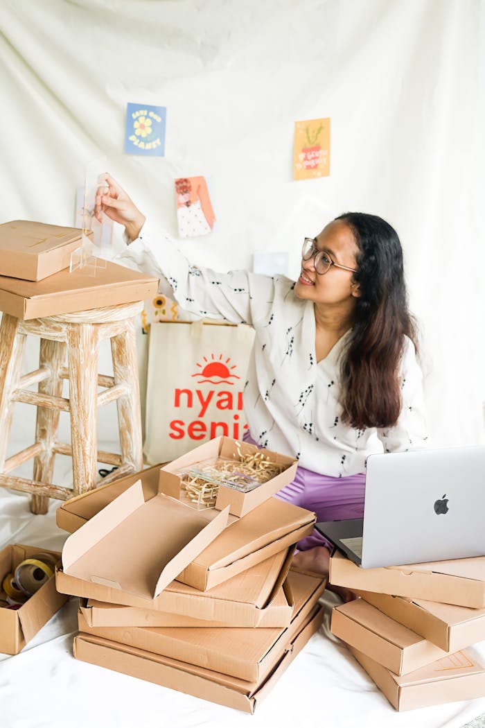 A female entrepreneur packs products in an organized workspace with creative decor.