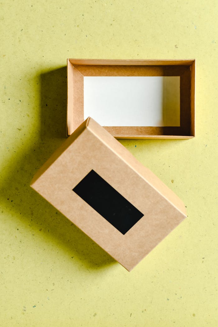 A minimalist shot of an open kraft paper box on a textured surface with emphasis on copy space.